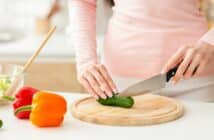 Woman Cutting Up a Cucumber on a Cutting Board, Cropped