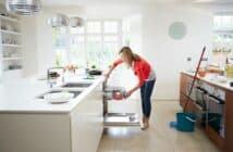 Woman Loading Plates Into Dishwasher