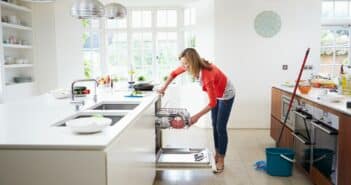 Woman Loading Plates Into Dishwasher