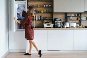 Woman looking into the fridge at home