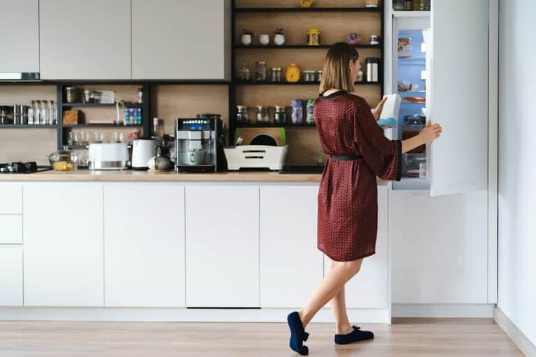 Woman looking into the fridge at home