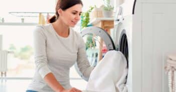 Woman putting clothes into washing machine