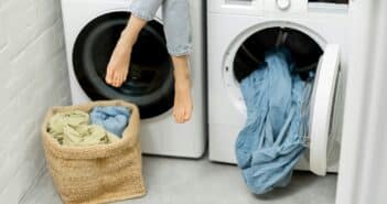 Woman sitting over the washing and dryer machines