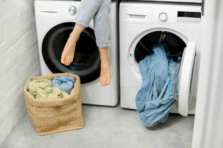 Woman sitting over the washing and dryer machines