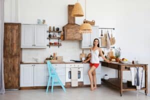 Woman standing by the stove in the kitchen