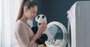 Woman washing a panda plush in the washing machine