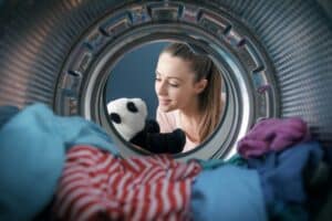 Woman washing a plush in the washing machine