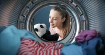 Woman washing a plush in the washing machine