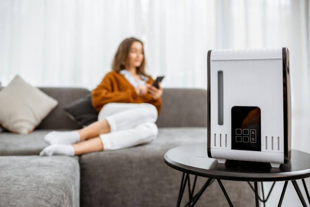 Woman with air humidifier at home