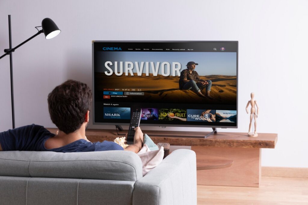 Un jeune homme dans son canapé regardant Netflix sur une TV LED