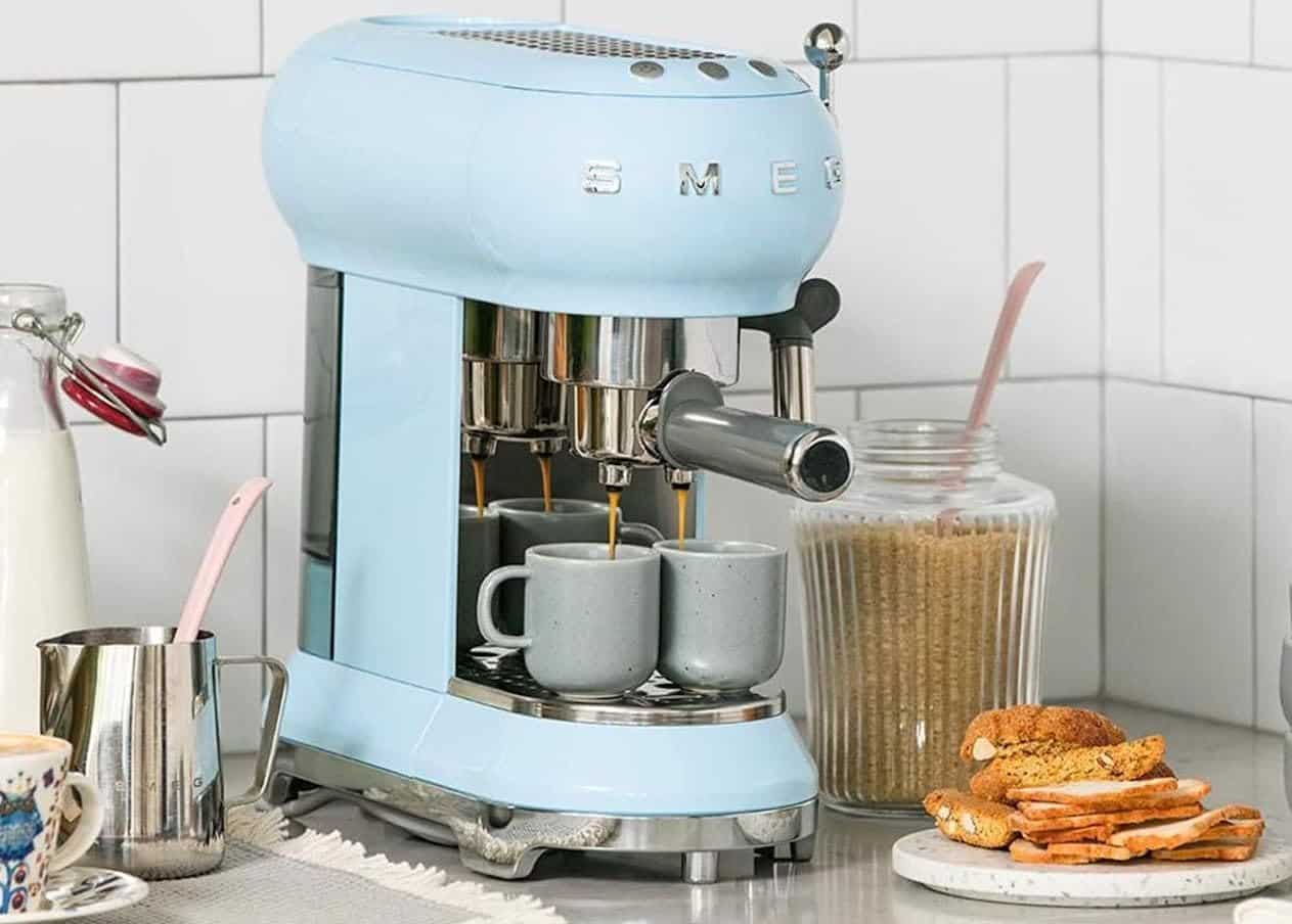 Machine à café de la marque Smeg sur un plan de travail.