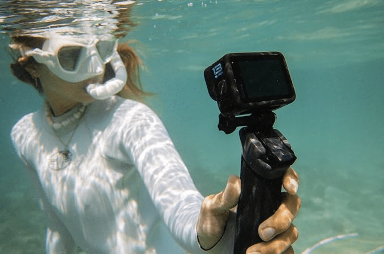 Une femme qui tulise une caméra de la marque GoPro sous l'eau.