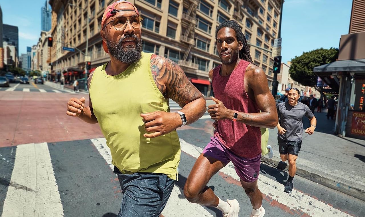 Trois coureurs à New York City qui portent des bracelets connectés de la marque Fitbit.