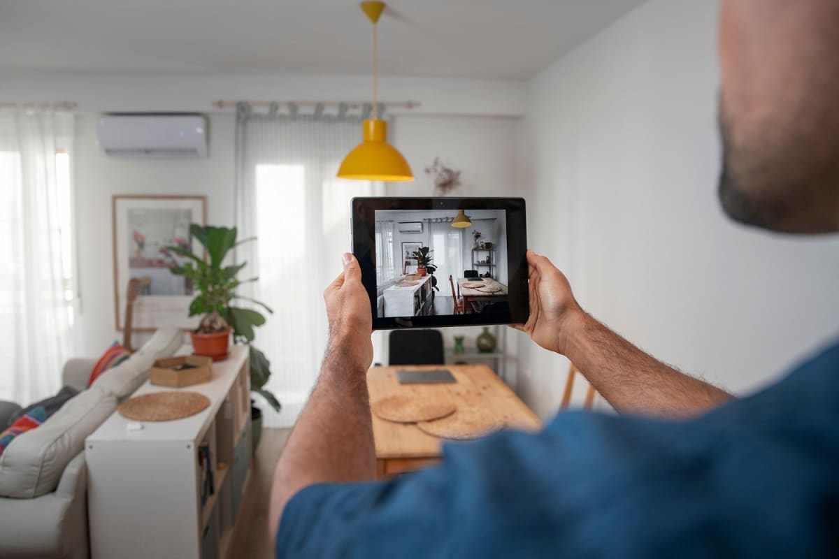 Un homme utilise la video surveillance d'un appartement d'un senior sur une tablette tactile